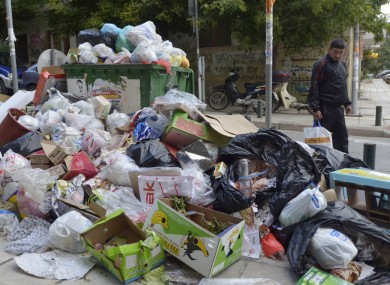 A pedestrian walks past a pile of garbage at the northern port city of Thessaloniki. Greek riot police have removed strikers from a landfill site northwest of Athens to allow access for private contractors brought in to clear the streets of garbage.