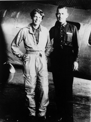 Amelia Earhart and her navigator Fred Noonan posing in front of their Lockheed Electra in May 1937.