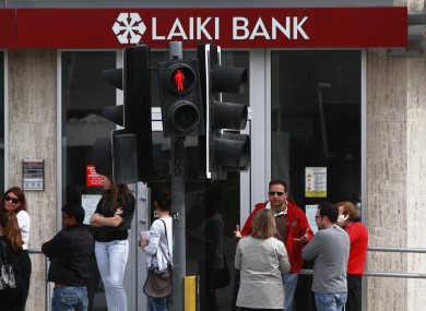 People wait and use the ATM of a closed branch of Laiki Bank in capital Nicosia