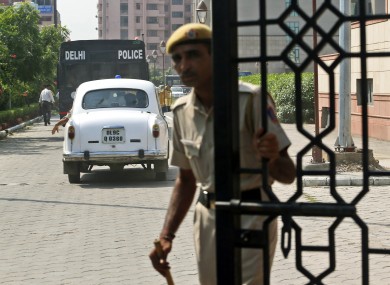 A policemen closes the gate of a court after a van, carrying the four men accused in the rape case enters.