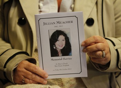 A mourner holds a mass card at the memorial mass for Jill Meagher in Louth last year.