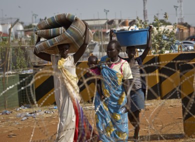 Displaced women carry belongings after seeking refuge at the compound of the United Nations Mission in South Sudan (UNMISS), in Juba, South Sudan