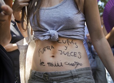 A protester shows body paint reading