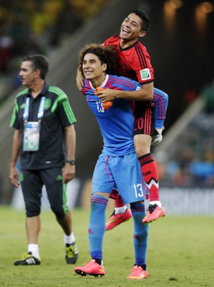 Ochoa gives Mexico teammates Javier Aquino a piggyback after the 0-0 draw with Brazil.